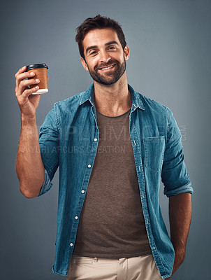 Buy stock photo Studio shot of a handsome young man drinking a cup of coffee against a grey background