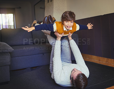 Buy stock photo Shot of a man lifting his son into mid-air