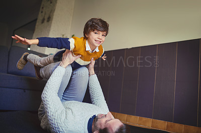 Buy stock photo Shot of a man lifting his son into mid-air