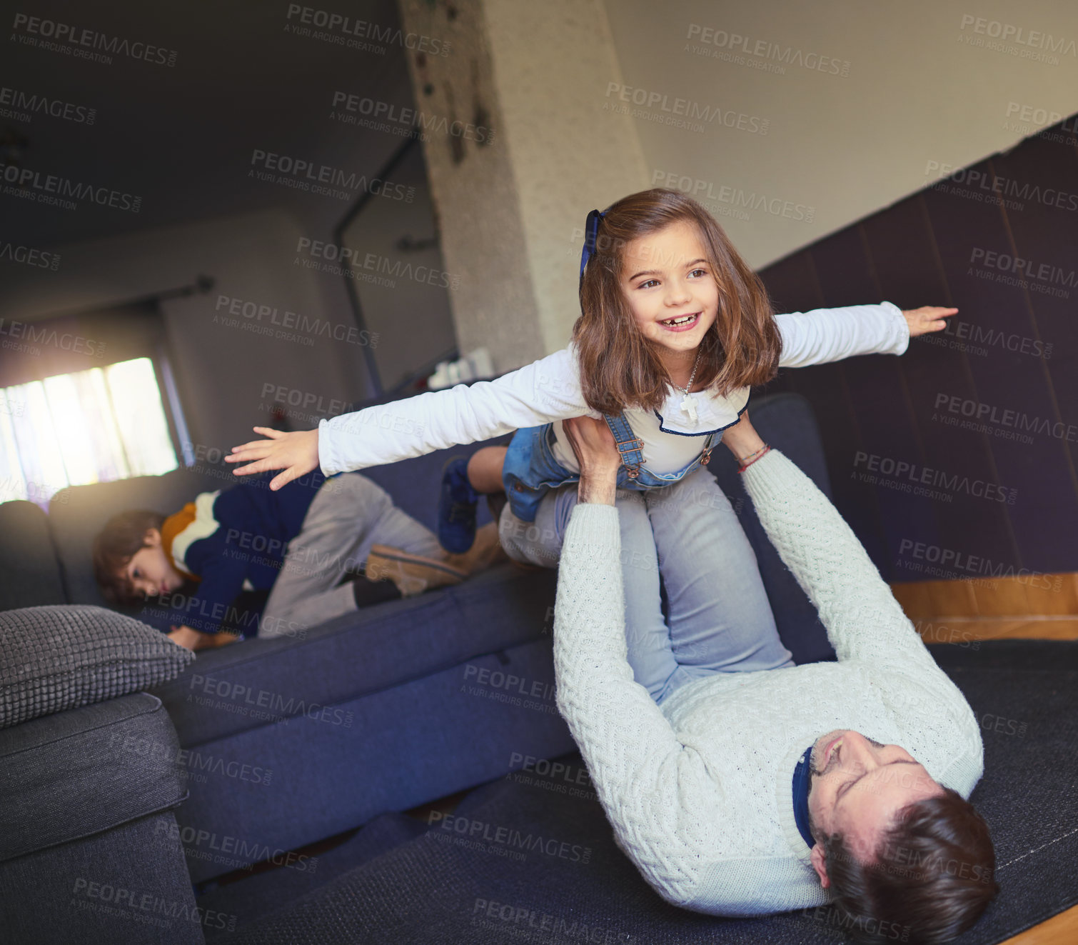 Buy stock photo Shot of a man lifting his daughter into mid-air