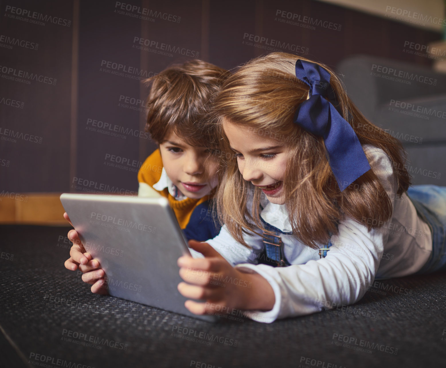 Buy stock photo Shot of a little boy and girl using a digital tablet at home