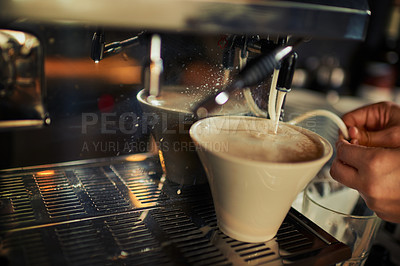 Buy stock photo Closeup of an unrecognizable person pouring hot milk into a cup of coffee inside of a restaurant during the day
