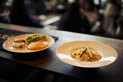 Buy stock photo Shot of two plates of food standing on a counter and ready to be taken out to customers inside of a restaurant during the day