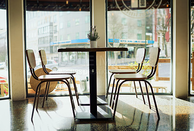 Buy stock photo Shot of an empty table with chairs inside of a restaurant during the day