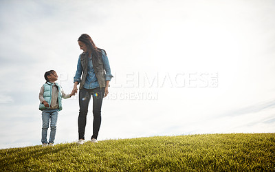 Buy stock photo Shot of a woman holding her little girl's hand as they walk outdoors