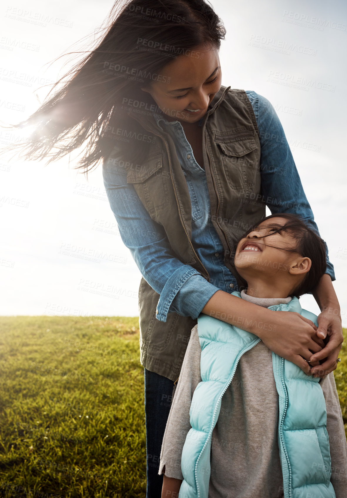 Buy stock photo Shot of a mother embracing her daughter from behind
