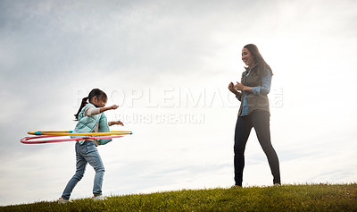 Buy stock photo Child, countryside and hoop with woman and clapping, support and babysitter for holiday activity. Childcare, love and plastic ring with female person, autumn and nanny for cloudy sky in field 