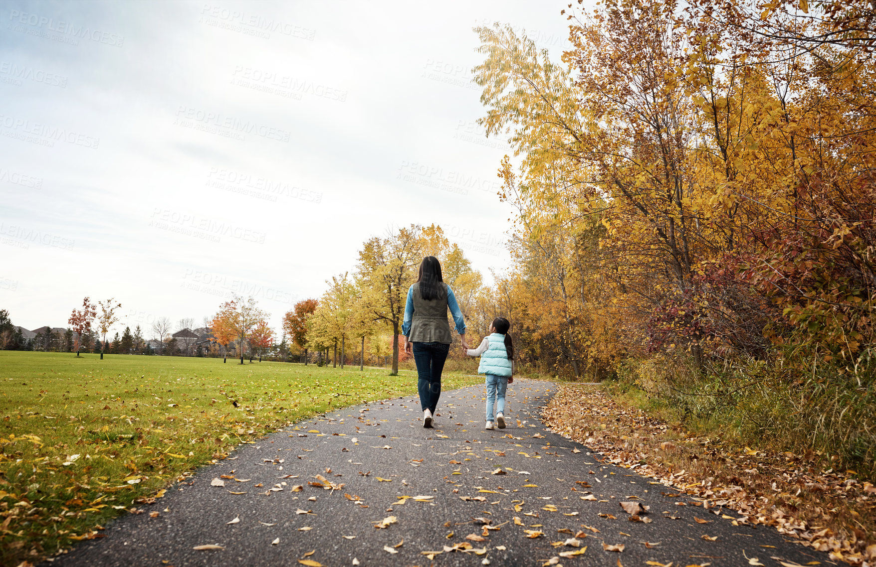 Buy stock photo Rearview shot of a mother and her little daughter enjoying a walk outdoors