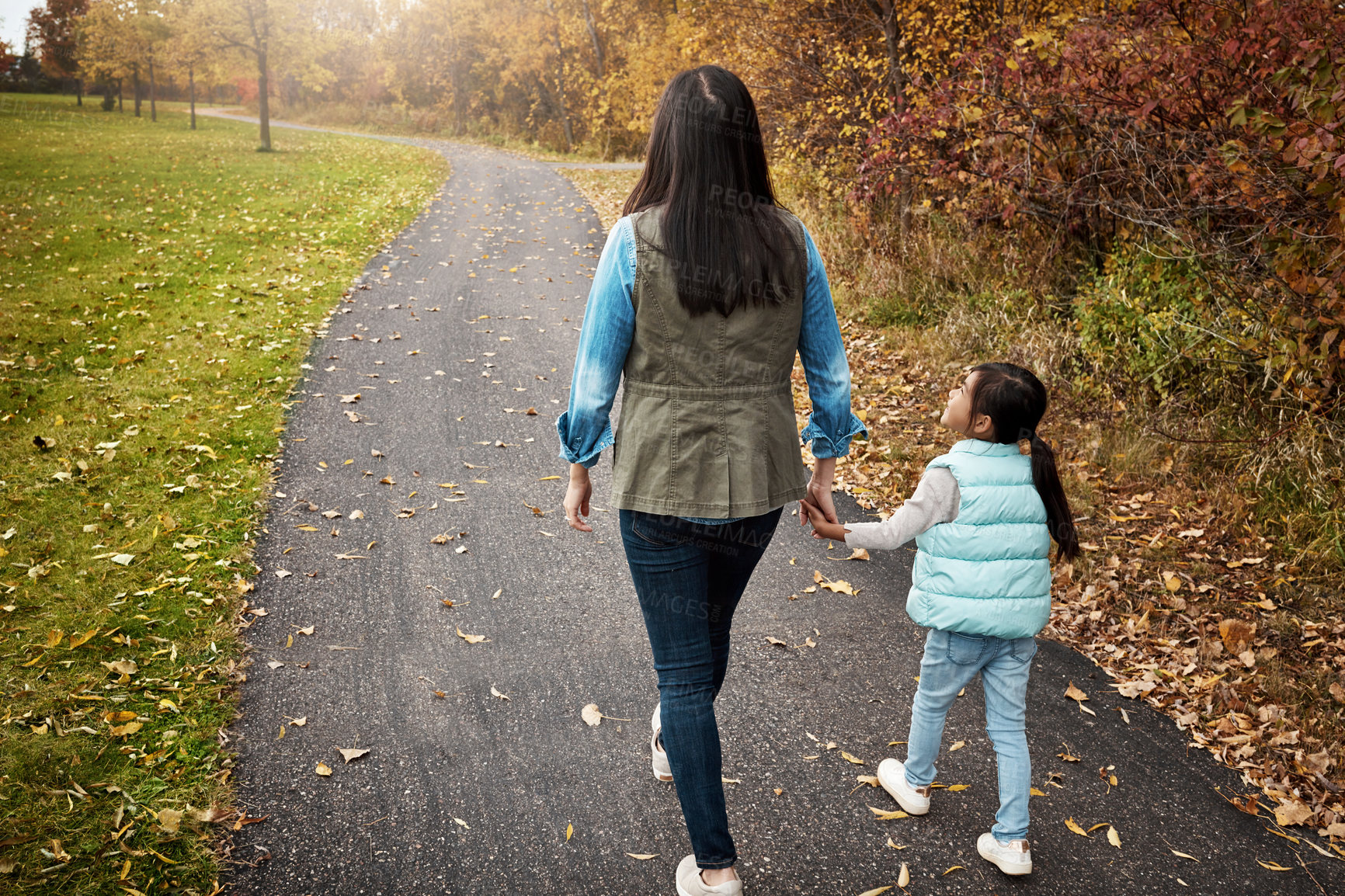 Buy stock photo Back view, mother and holding hands with daughter for walk, bonding or outdoor adventure on journey in nature. Mom strolling with kid, child or little girl on sidewalk, autumn season or park together