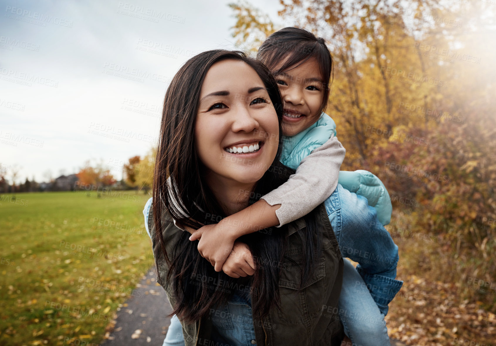 Buy stock photo Portrait, asian family and piggy back for walk, bonding together and countryside for holiday. Face, parent and girl with smile, outdoor and mother carrying kid, nature and energy with game or playing