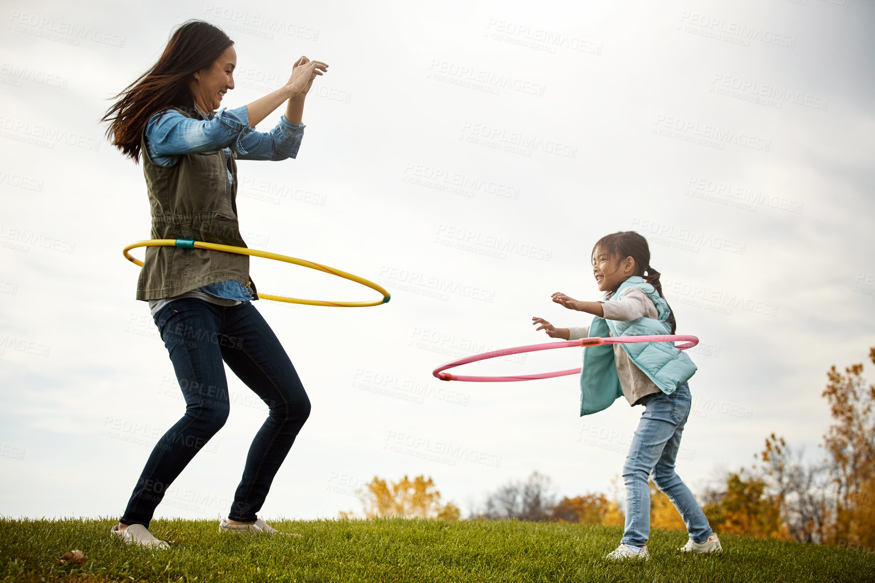 Buy stock photo Mom, daughter and dance with hoop in nature, play and field in autumn for activity. Child, together and bonding with female person or mother with girl, outdoor and trees for holiday in park with toys