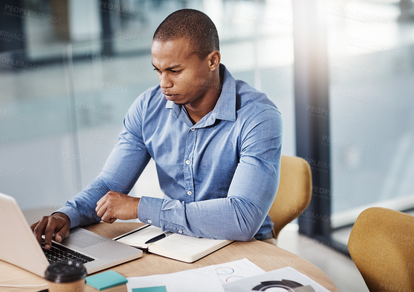 Buy stock photo High angle shot of a young businessman working in his office