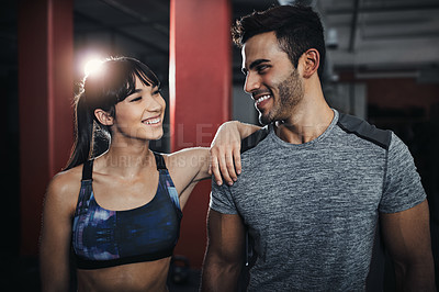 Buy stock photo Shot of two young people at the gym for a workout