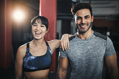 Buy stock photo Shot of a sporty young man and woman standing together in the gym