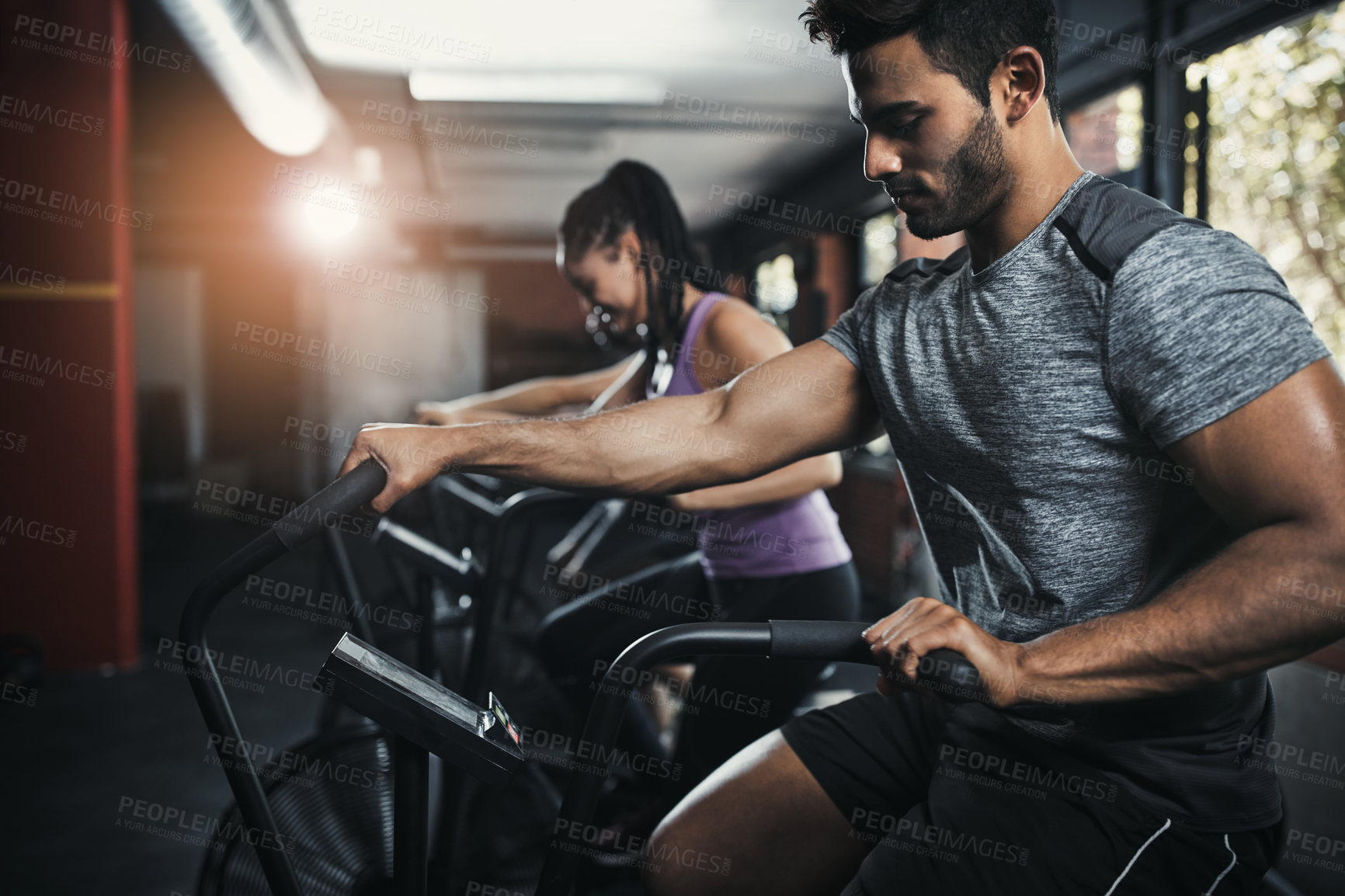 Buy stock photo Shot of young people working out in the gym