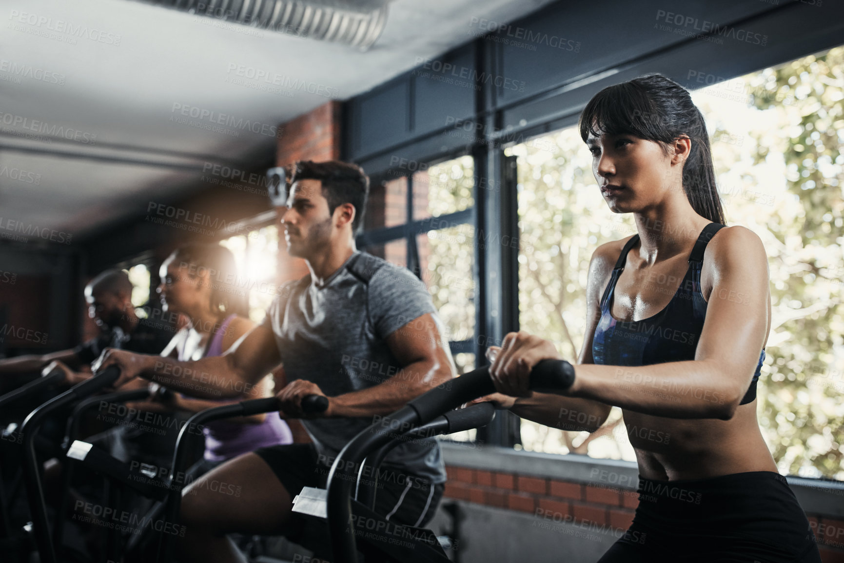 Buy stock photo Shot of young people working out in the gym