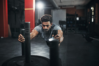 Buy stock photo Shot of a handsome young man working out at the gym