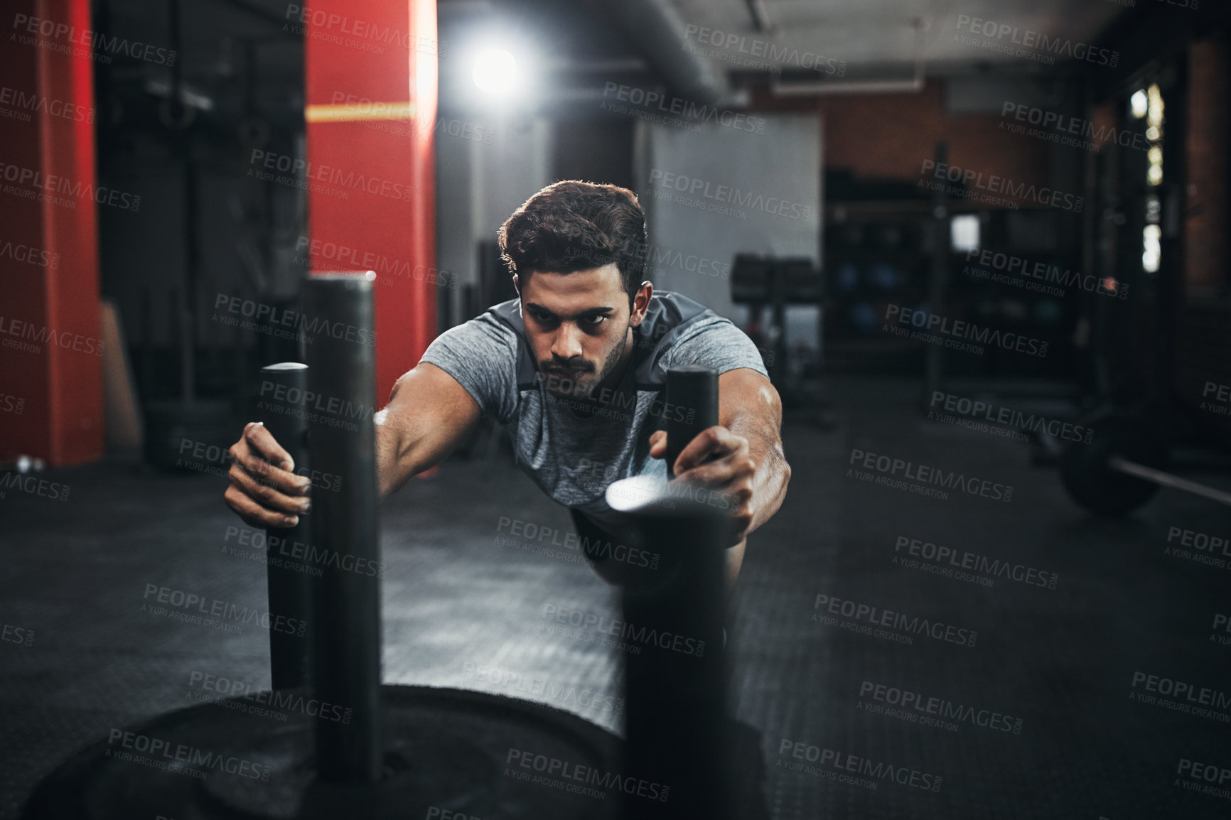 Buy stock photo Shot of a handsome young man working out at the gym