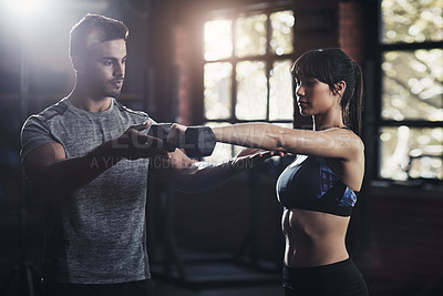 Buy stock photo Cropped shot of a young man and woman working out at the gym
