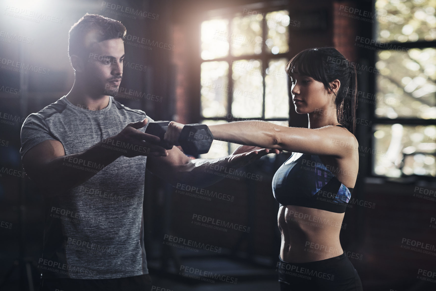 Buy stock photo Cropped shot of a young man and woman working out at the gym