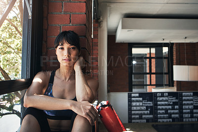 Buy stock photo Shot of a beautiful young woman sitting at the gym