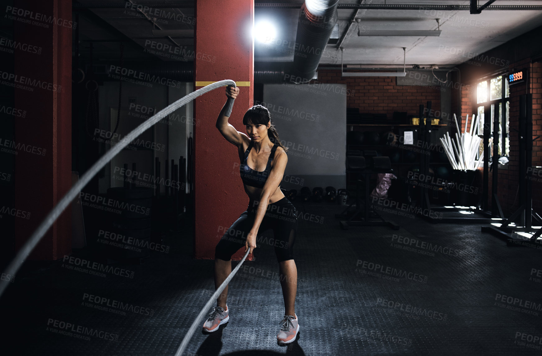 Buy stock photo Shot of a young woman doing heavy rope training at the gym
