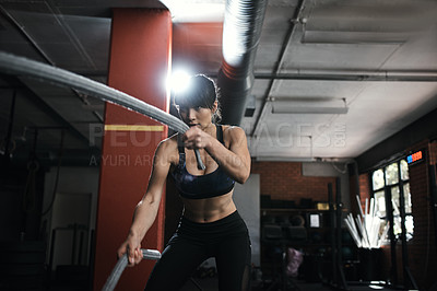 Buy stock photo Shot of a young woman doing heavy rope training at the gym