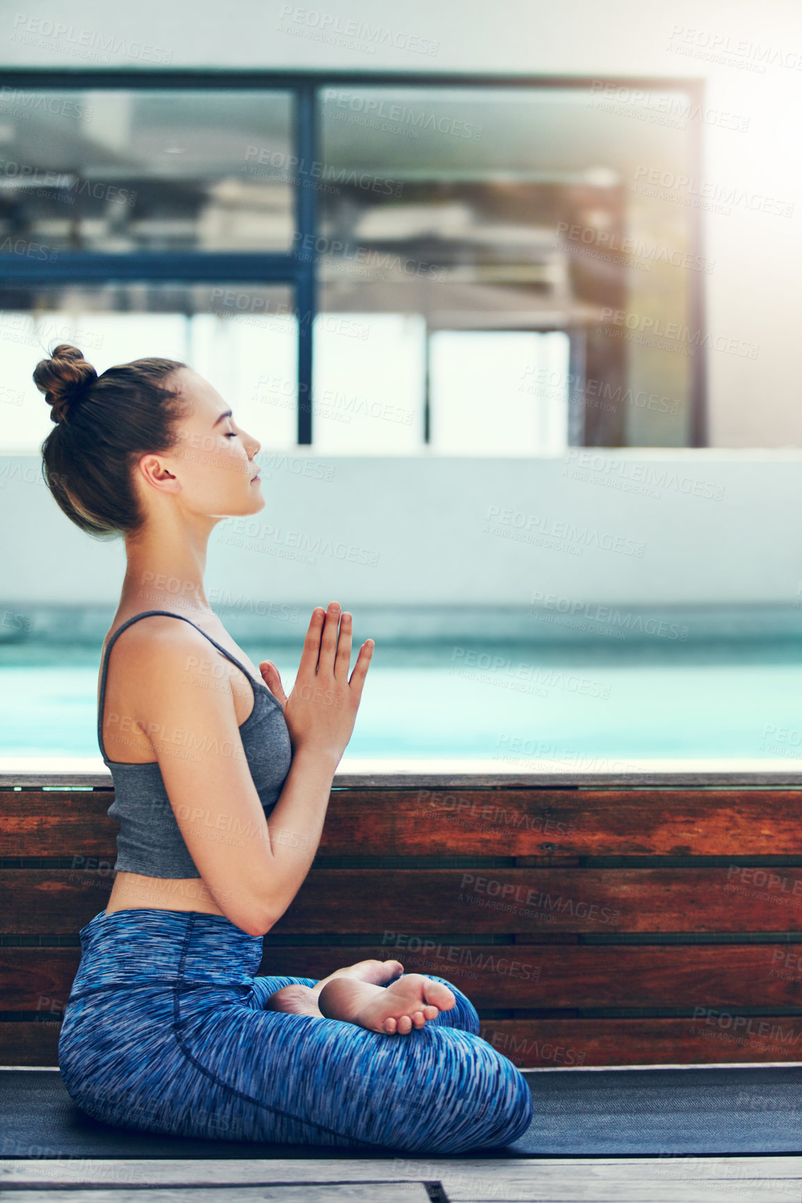 Buy stock photo Shot of a beautiful young woman practicing yoga outside