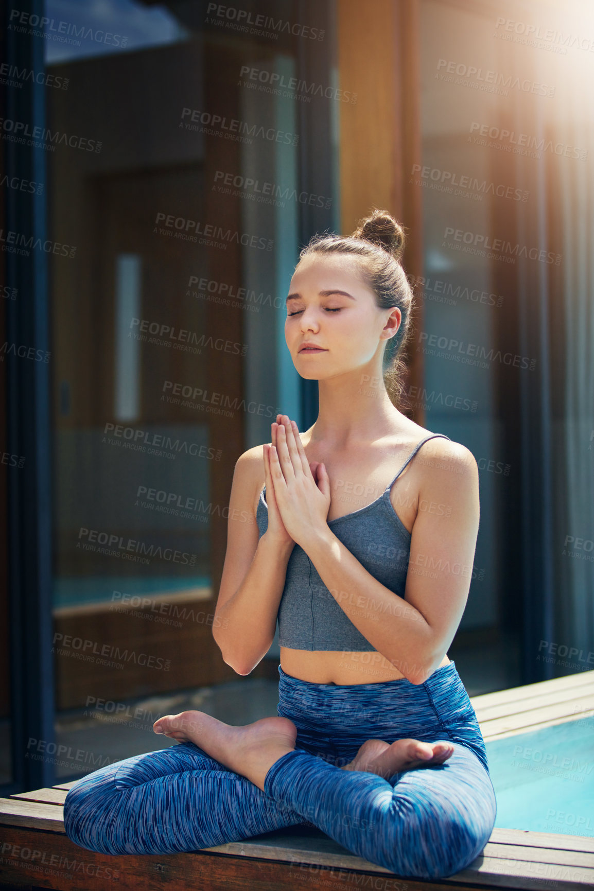 Buy stock photo Shot of a beautiful young woman practicing yoga outside