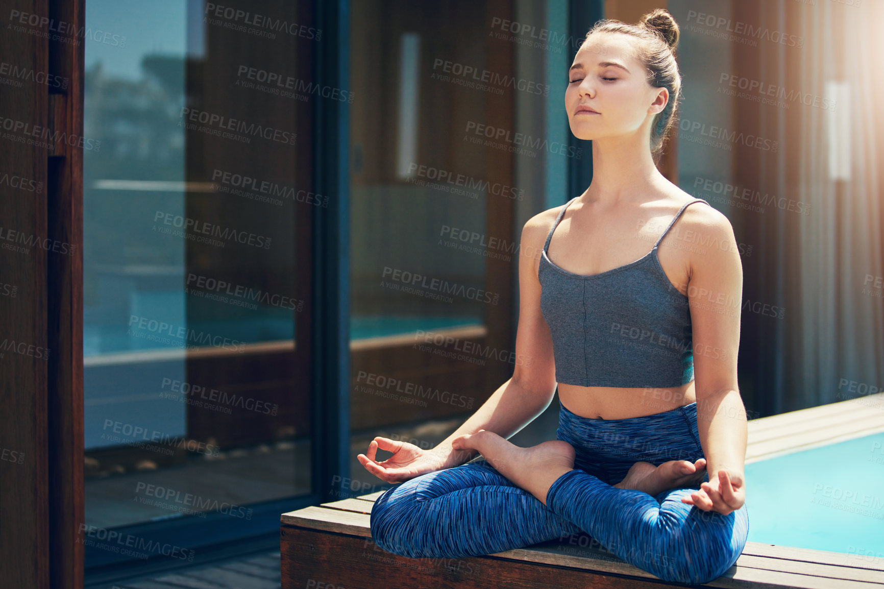 Buy stock photo Shot of a beautiful young woman practicing yoga outside