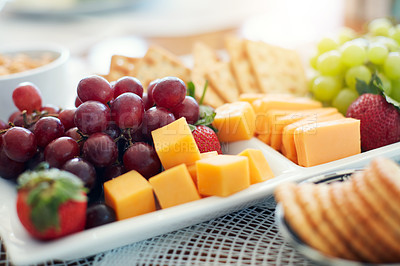 Buy stock photo Closeup, food and snack platter with fruit for healthy wellness, vitamin and vegetarian diet on table. Grapes, cheese and crackers on plate with nutrition, hungry eating and meal for brunch or picnic