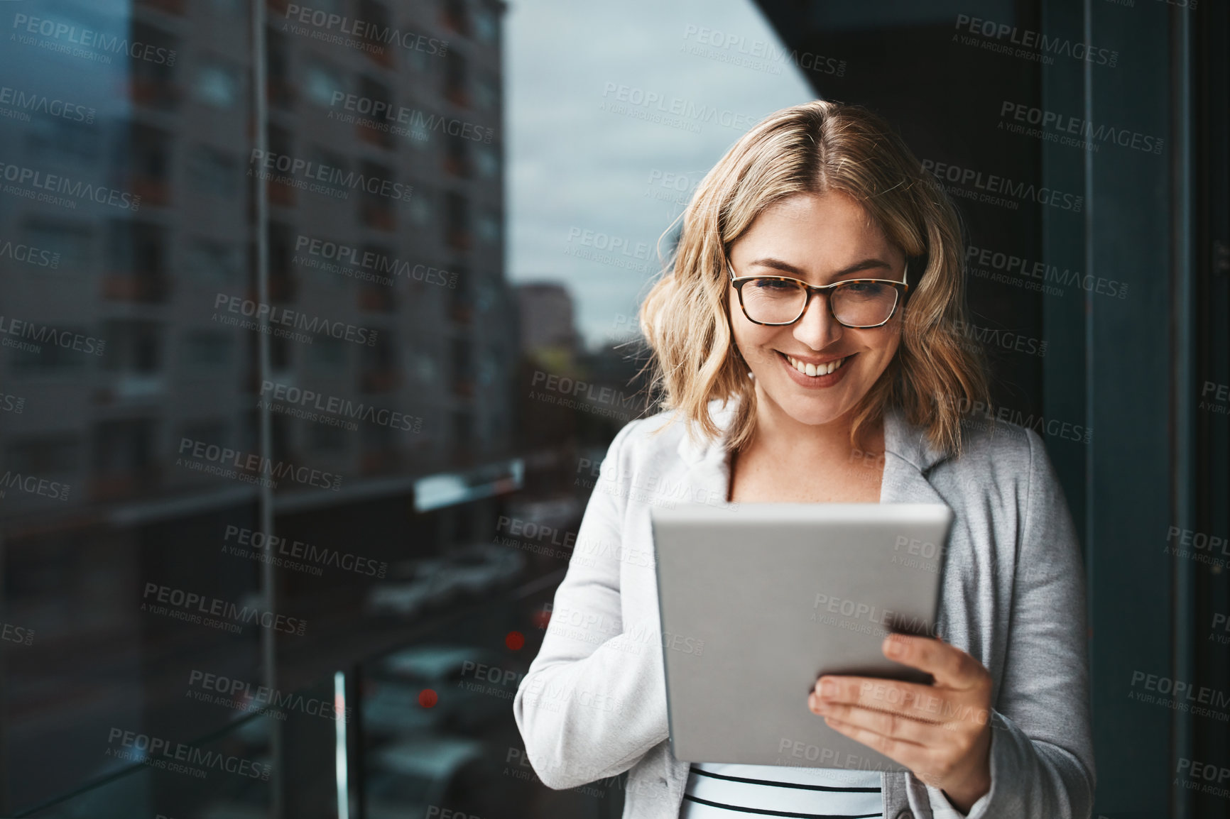 Buy stock photo Shot of a young businesswoman using a digital tablet on the office balcony