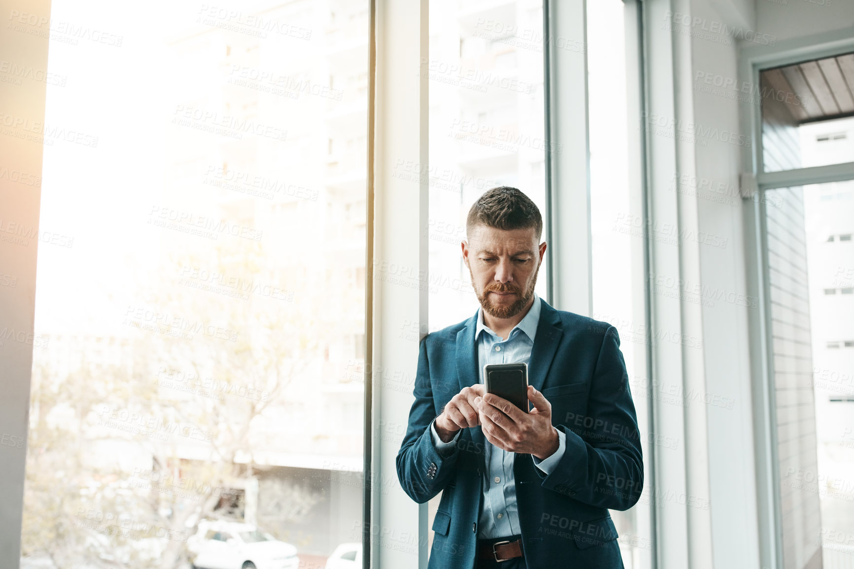 Buy stock photo Shot of a mature businessman using a cellphone in an office