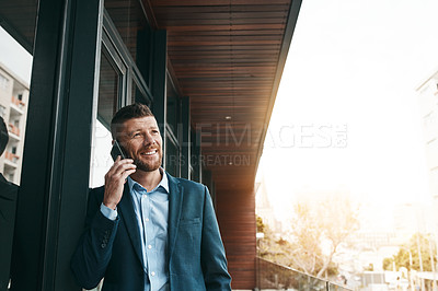 Buy stock photo Shot of a mature businessman talking on a cellphone on the office balcony