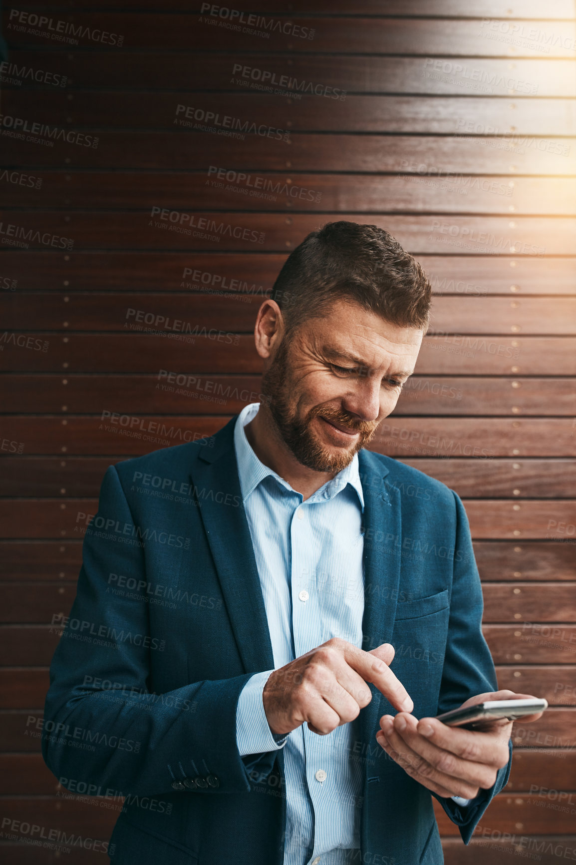 Buy stock photo Shot of a mature businessman using his cellphone on the office balcony