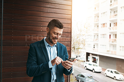 Buy stock photo Shot of a mature businessman using his cellphone on the office balcony