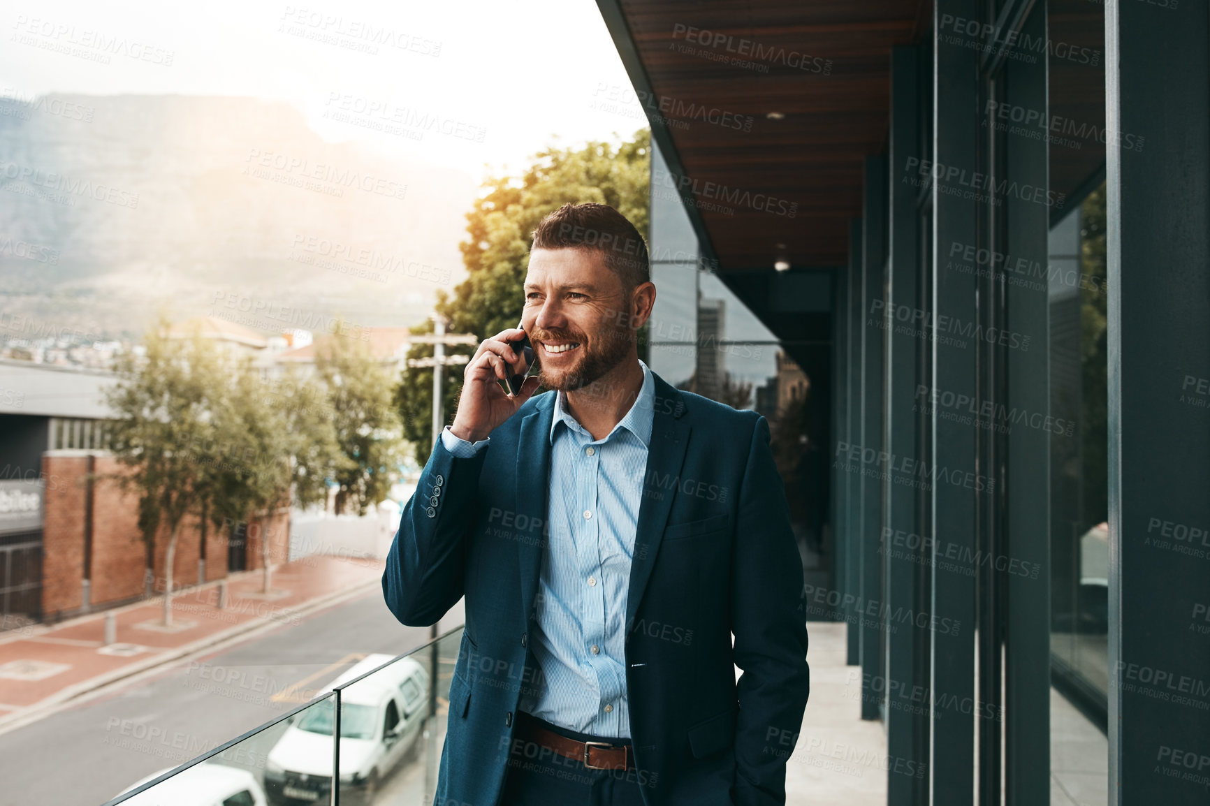 Buy stock photo Shot of a mature businessman talking on a cellphone on the office balcony