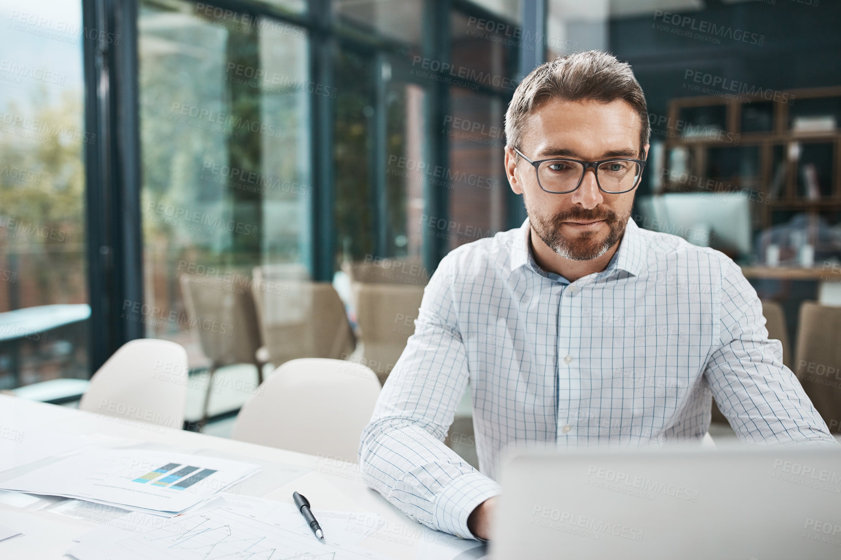 Buy stock photo Shot of a mature businessman working in an office