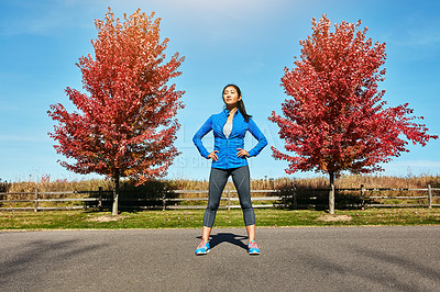 Buy stock photo Shot of a sporty young woman standing outdoors