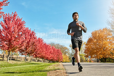 Buy stock photo Shot of a sporty young man running outdoors