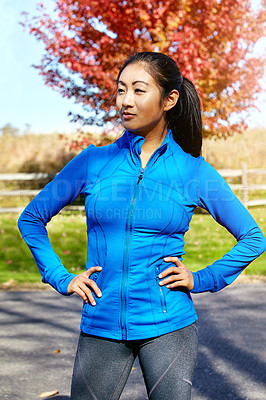 Buy stock photo Shot of a sporty young woman standing outdoors