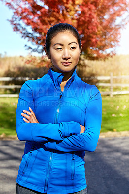 Buy stock photo Shot of a sporty young woman standing outdoors