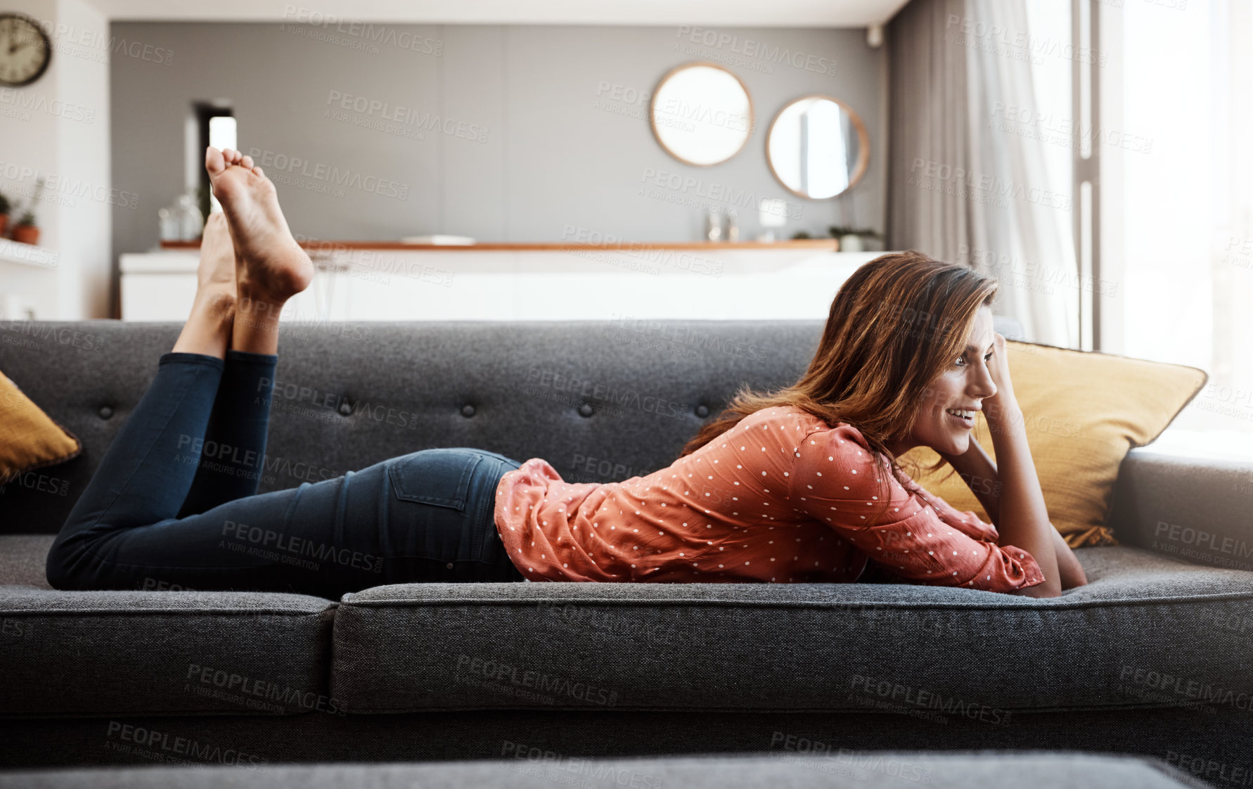 Buy stock photo Shot of an attractive young woman relaxing on the sofa at home