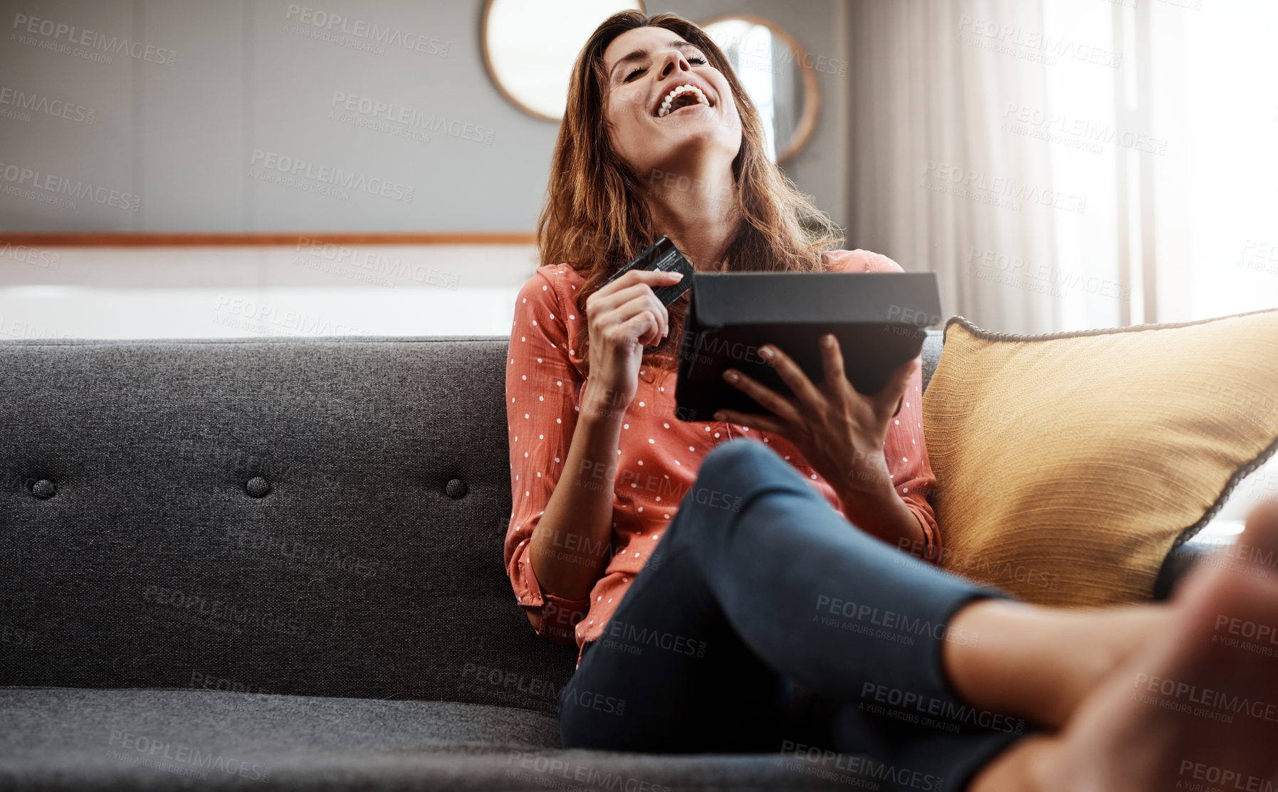 Buy stock photo Shot of an attractive young woman using a digital tablet and credit card on the sofa at home