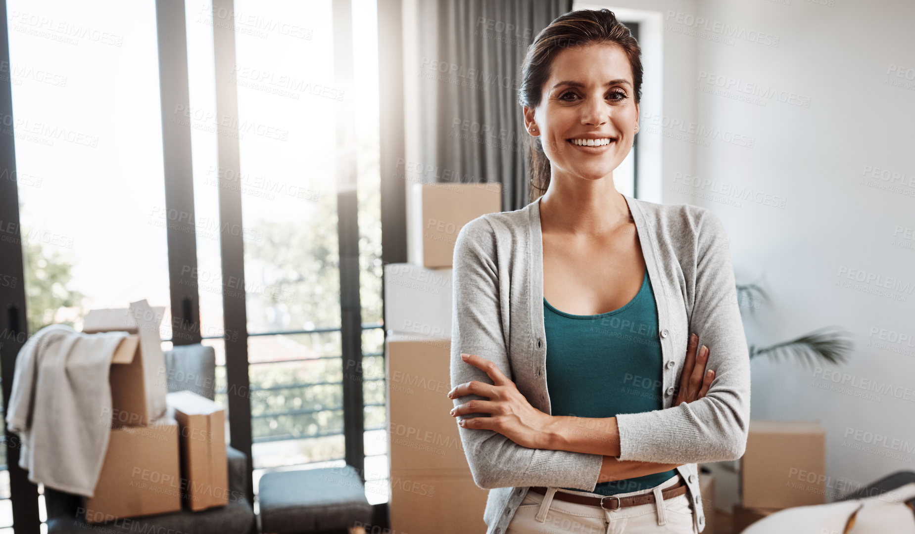 Buy stock photo Cropped portrait of an attractive young woman standing with her arms folded while moving into a new house