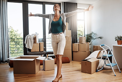 Buy stock photo Full length shot of an attractive young woman standing with her arms outstretched while moving into a new house