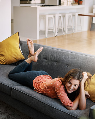 Buy stock photo Shot of an attractive young woman relaxing on the sofa at home