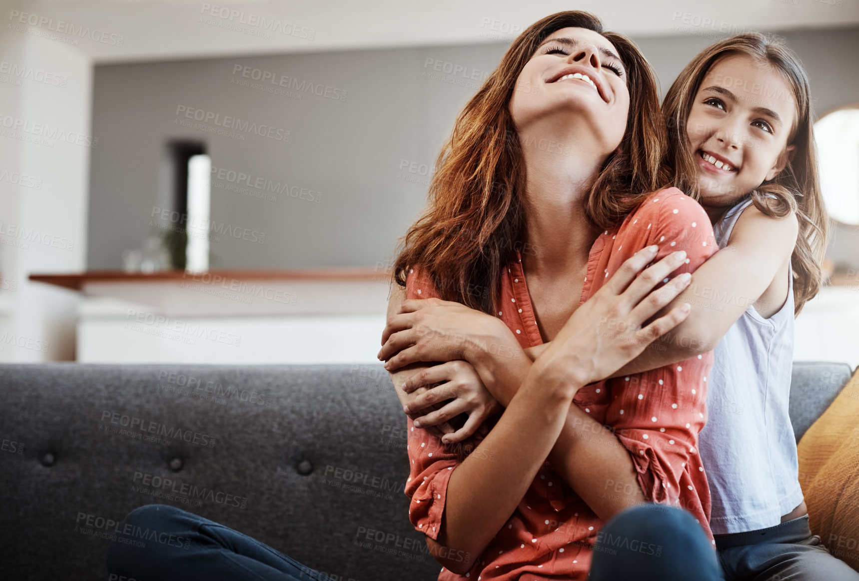 Buy stock photo Cropped shot of an attractive young woman and her daughter hugging while spending time together at home