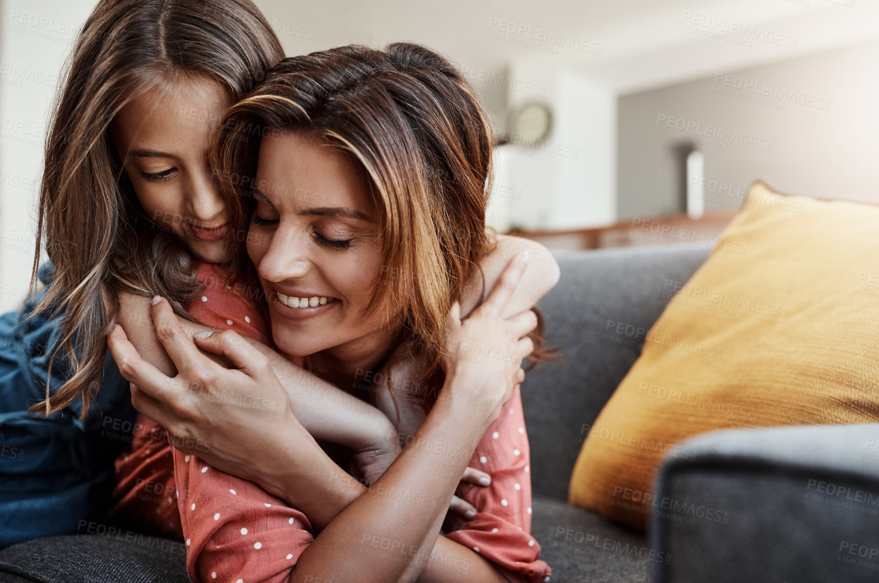 Buy stock photo Cropped shot of an attractive young woman and her daughter hugging while spending time together at home