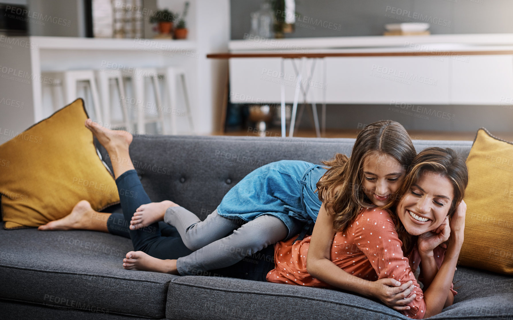 Buy stock photo Full length shot of an attractive young woman and her daughter hugging while spending time together at home